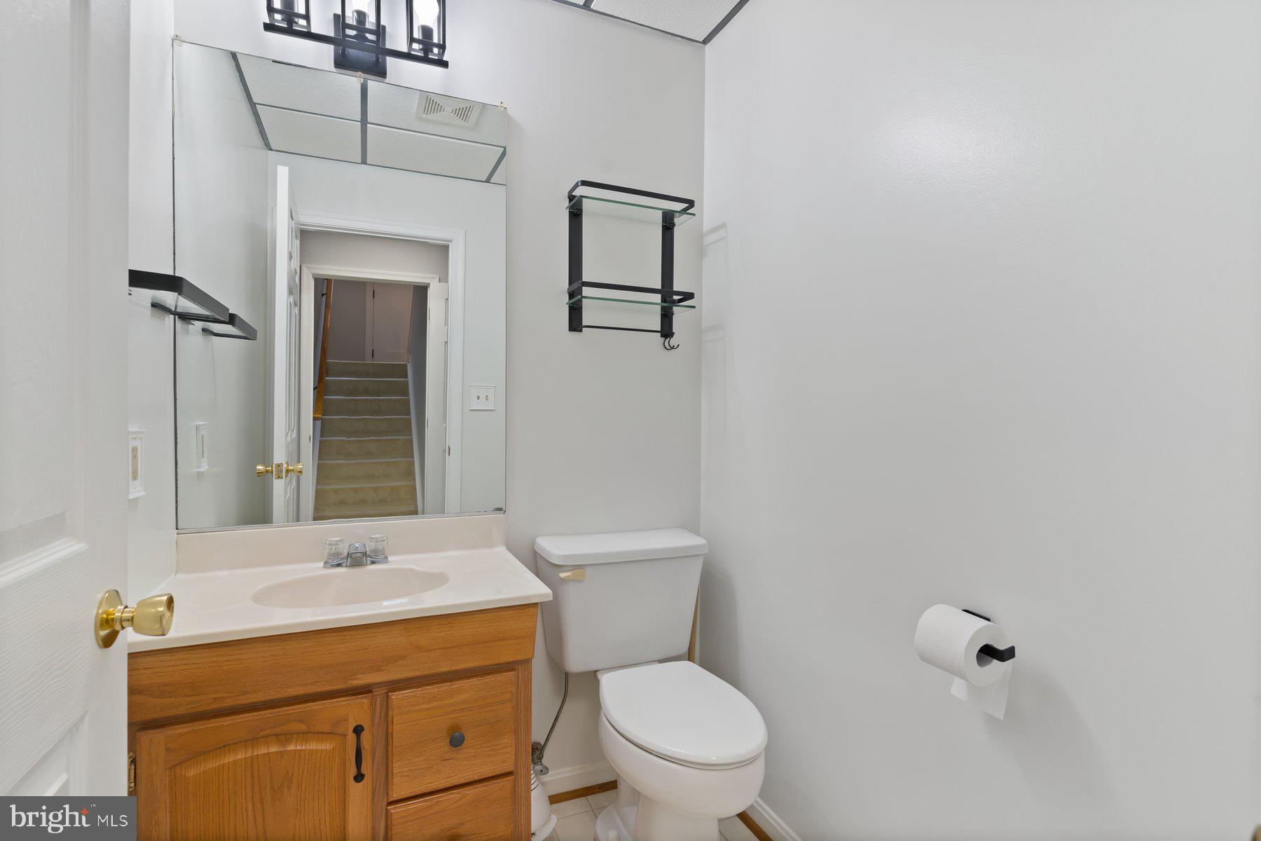 6571 11th Street Chesapeake Beach, MD 20732 - Photo 21 of 36 a bathroom with a toilet sink and mirror