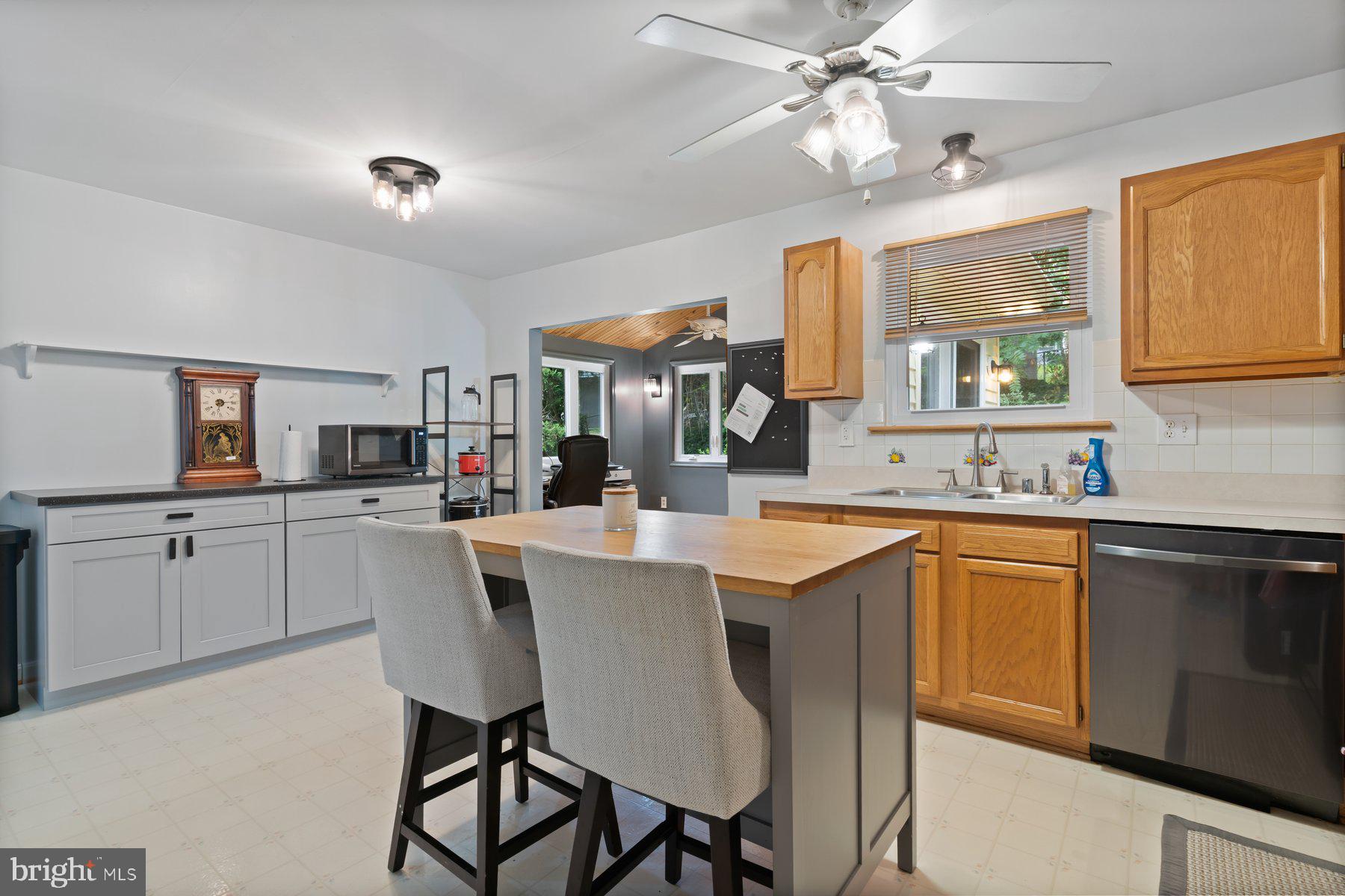 6571 11th Street Chesapeake Beach, MD 20732 - Photo 5 of 36 a kitchen with a dining table chairs cabinets and stainless steel appliances