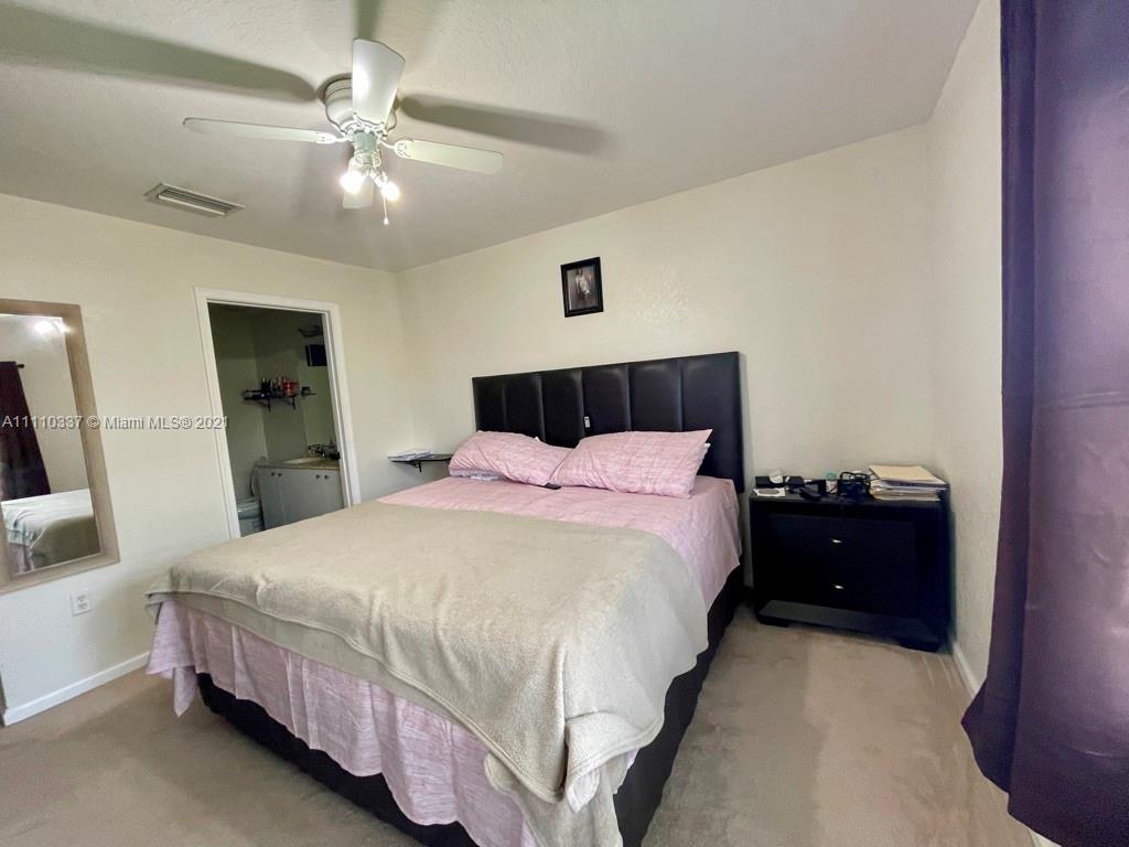 6317 Landings Terrace Tamarac, FL 33321 - Photo 18 of 20 a bedroom with a bed and a chandelier