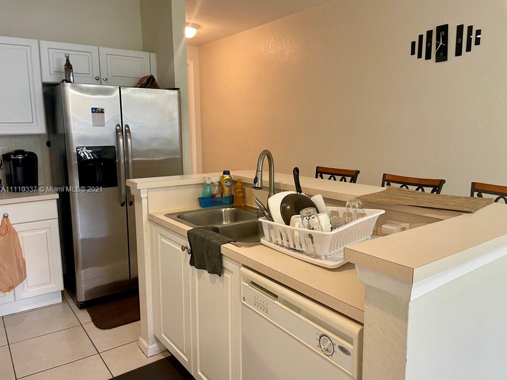 6317 Landings Terrace Tamarac, FL 33321 - Photo 6 of 20 a kitchen with refrigerator and washer