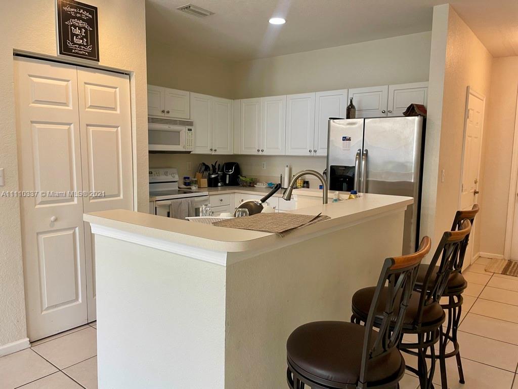 6317 Landings Terrace Tamarac, FL 33321 - Photo 7 of 20 a kitchen with a sink a refrigerator and cabinets