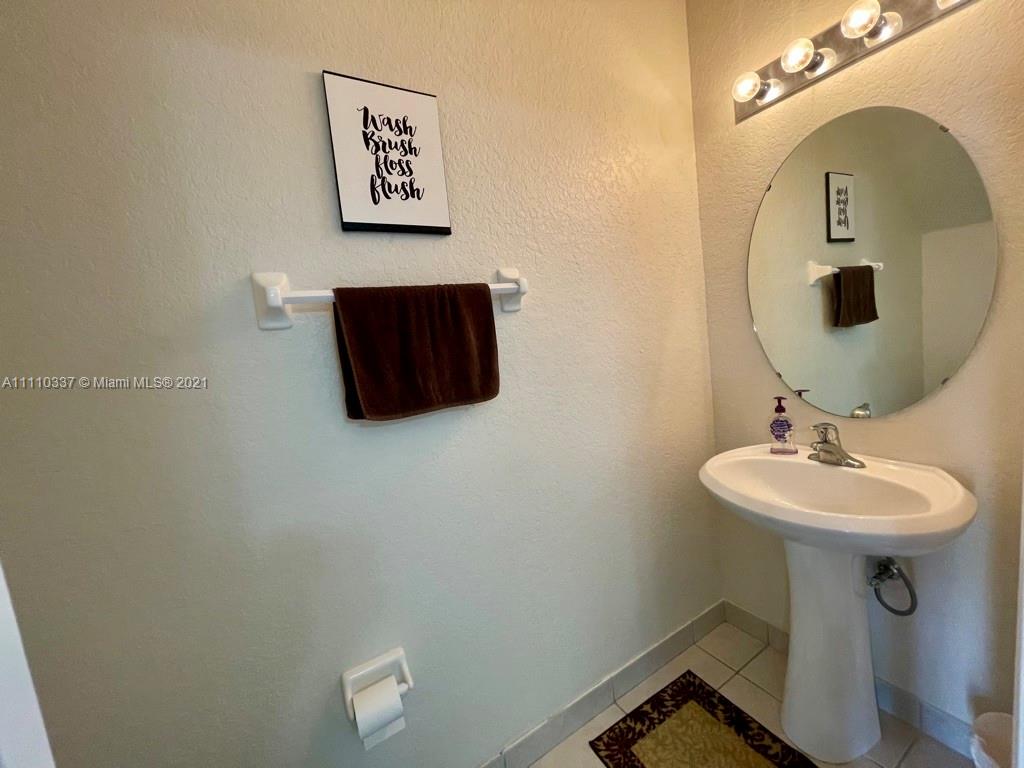 6317 Landings Terrace Tamarac, FL 33321 - Photo 8 of 20 a bathroom with a sink and mirror