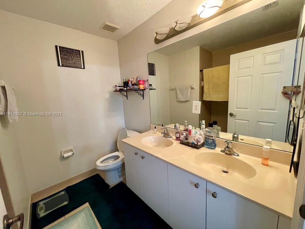 6317 Landings Terrace Tamarac, FL 33321 - Photo 10 of 20 a bathroom with a sink a toilet and mirror