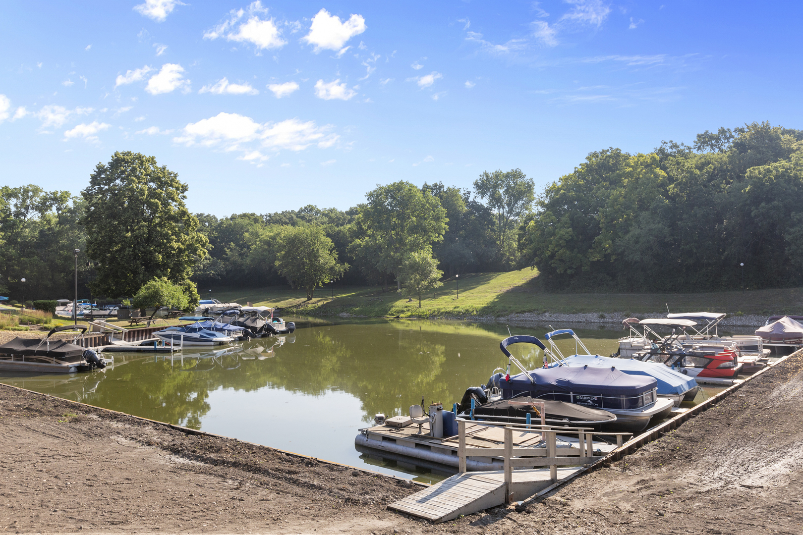 58 Vail Colony, Unit 10 Fox Lake, IL 60020 - Photo 24 of 28 a view of a lake with a table and chairs under an umbrella
