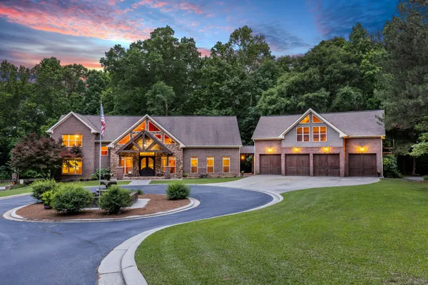 a front view of a house with yard and green space