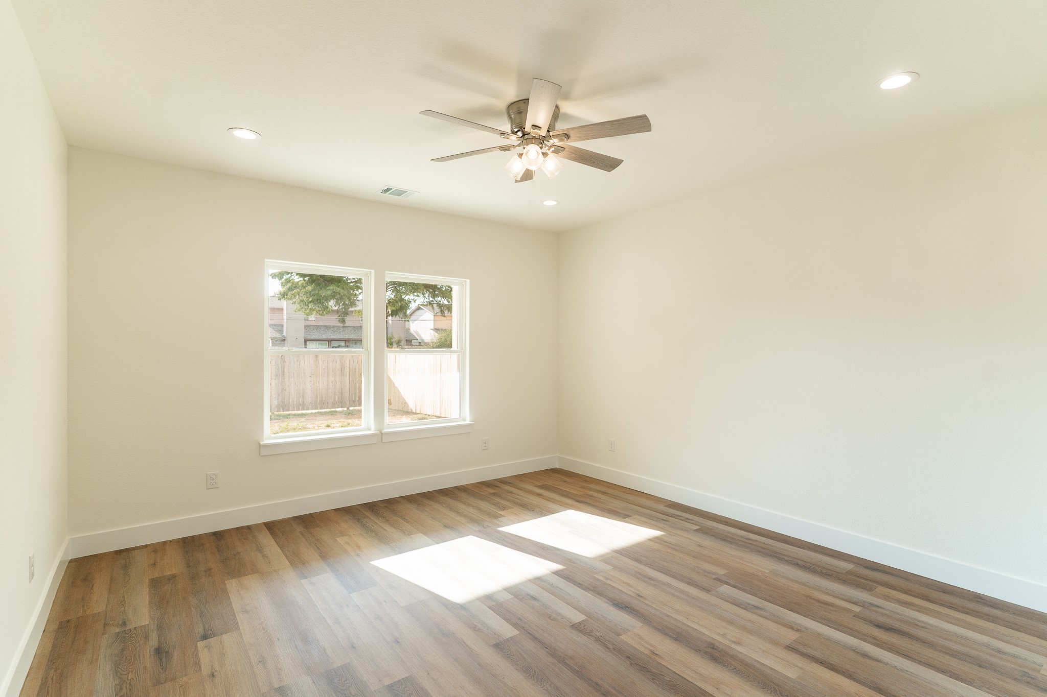 309 String Prairie Way Smithville, TX 78957 - Photo 15 of 30 an empty room with wooden floor a ceiling fan and windows
