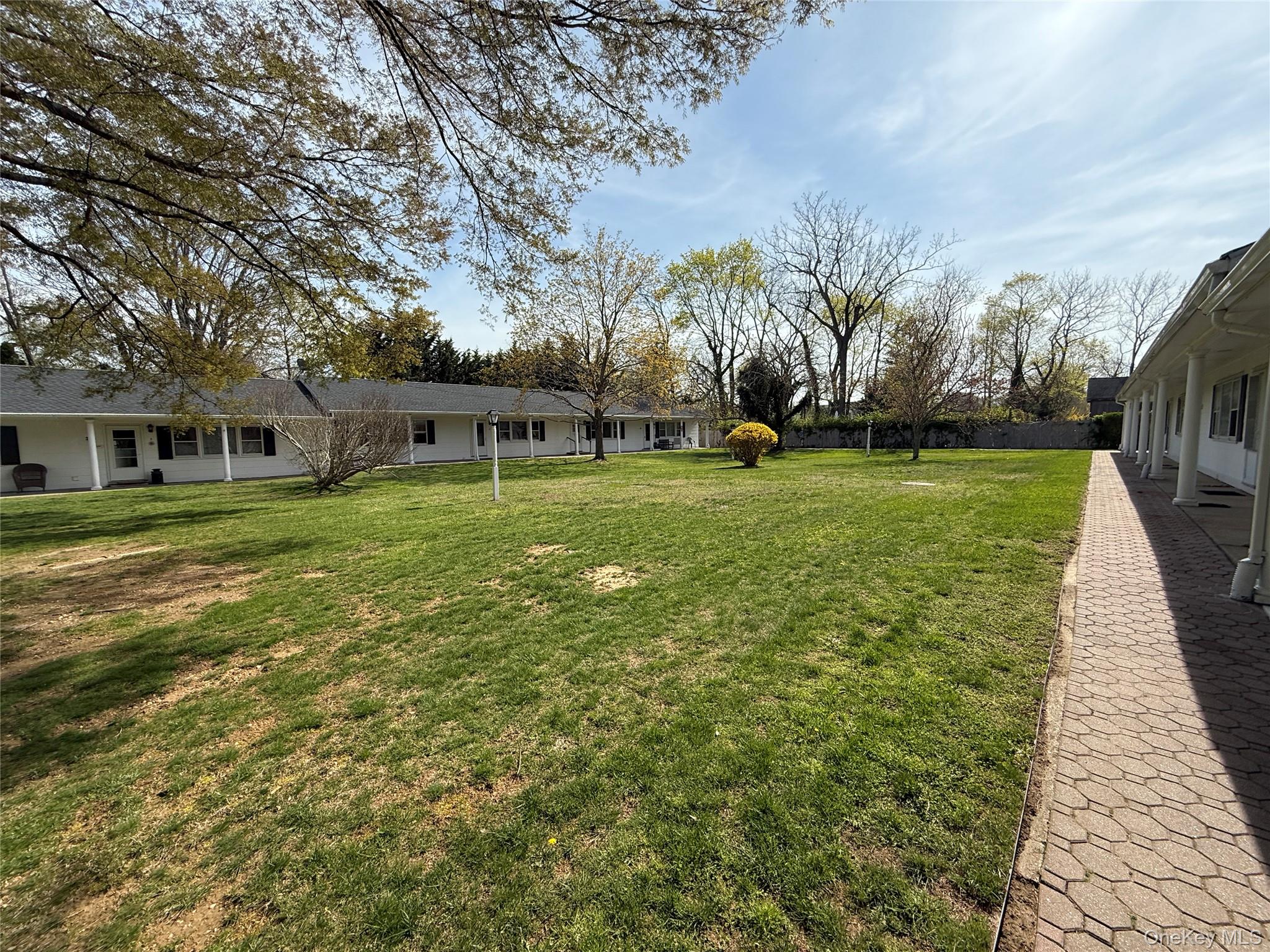 55075 Main Road, Unit YOUNGS BLDG #3 Southold, NY 11971 - Photo 9 of 16 a view of a house with a big yard and large trees