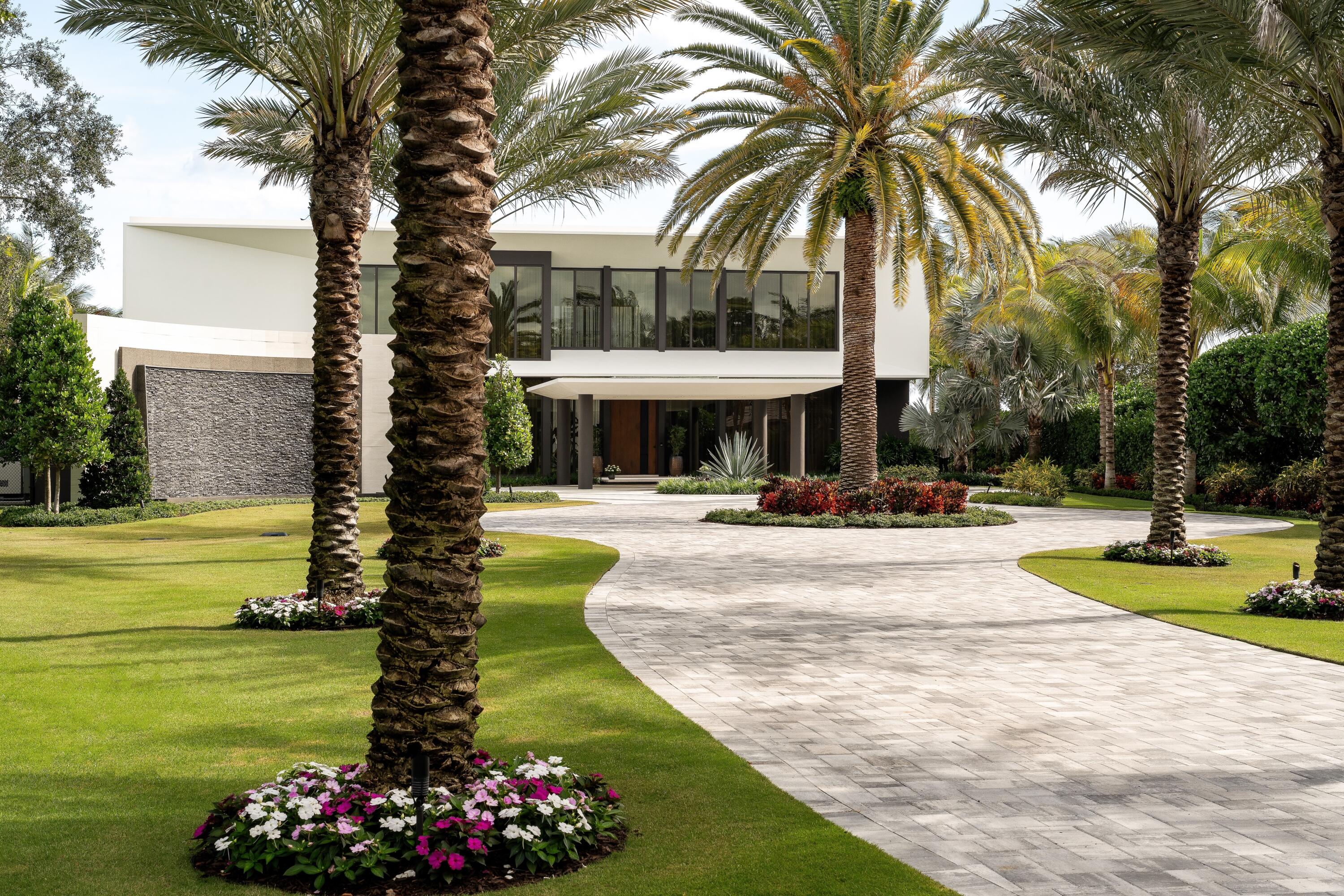5211 Pennock Point Road Jupiter, FL 33458 - Photo 5 of 69 a view of a swimming pool with a garden and palm trees