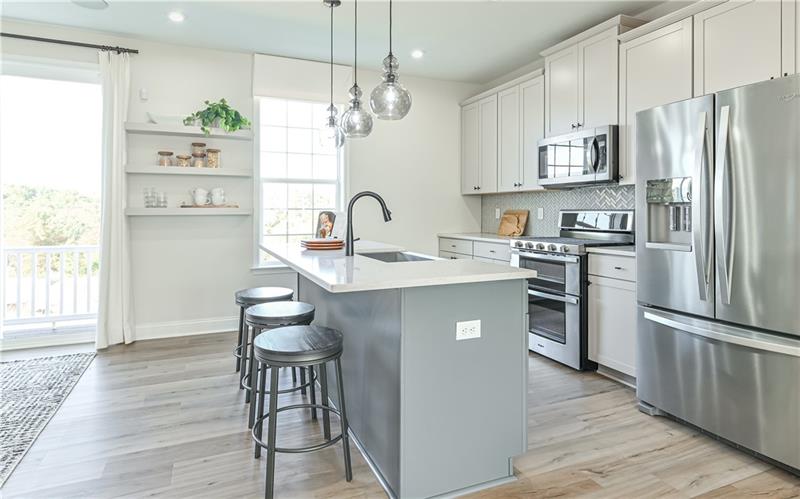 113 Affinity Drive Harmony, PA 16037 - Photo 5 of 40 a kitchen with stainless steel appliances granite countertop a refrigerator a sink dishwasher a stove and a dining table with wooden floor
