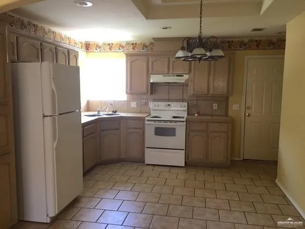 a kitchen with a refrigerator sink and cabinets