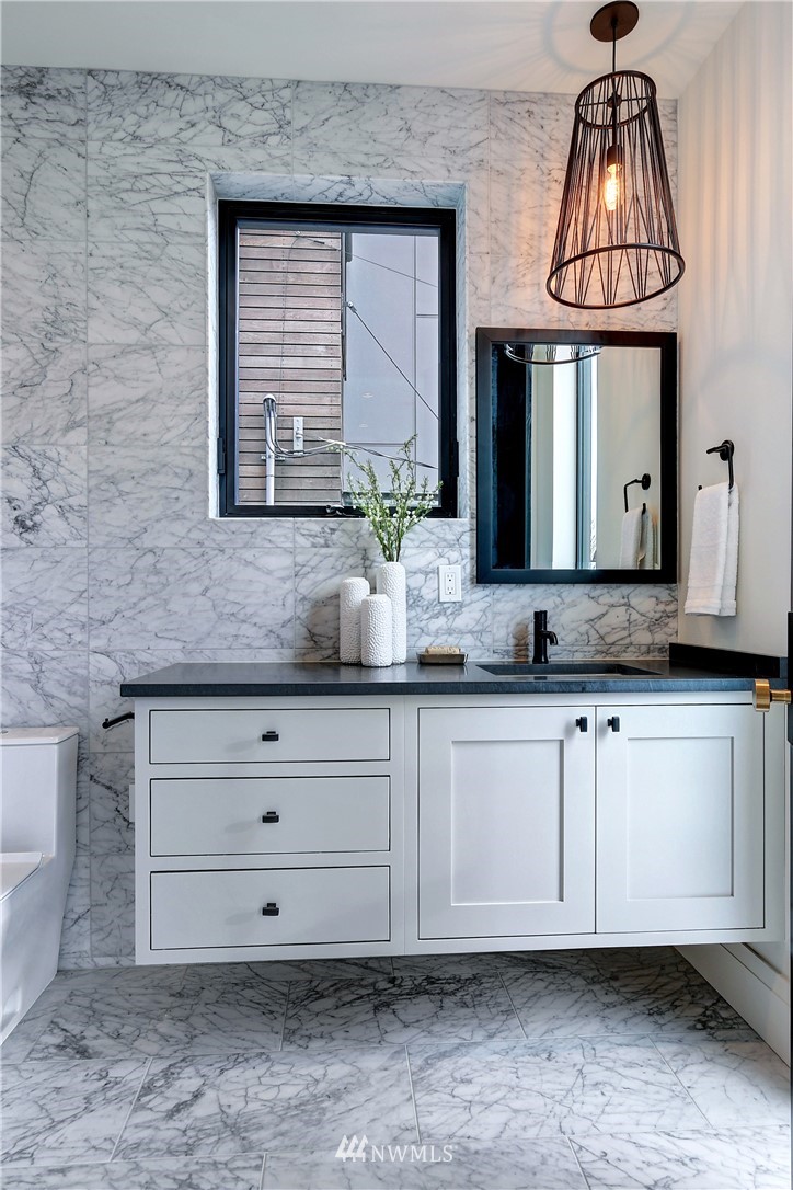 362 Ward Street Seattle, WA 98109 - Photo 19 of 40 a bathroom with a sink a granite counter and a mirror