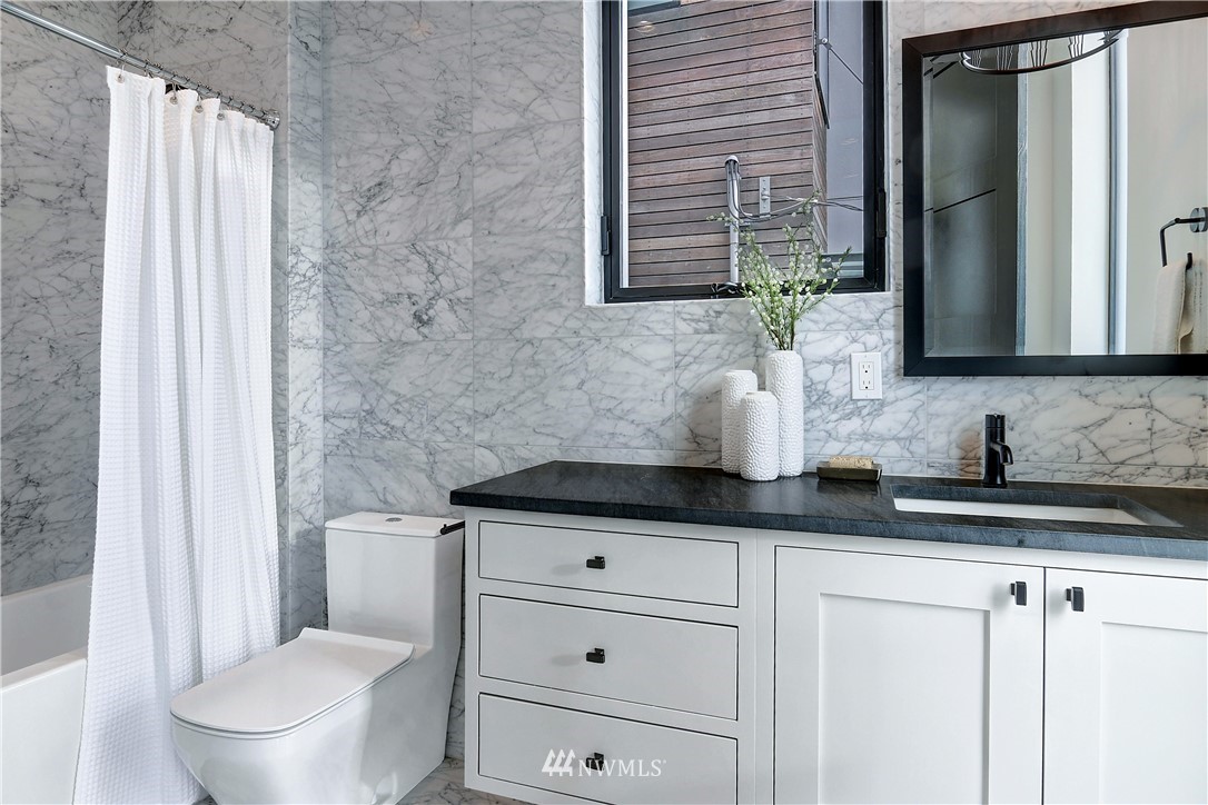 362 Ward Street Seattle, WA 98109 - Photo 20 of 40 a bathroom with a granite countertop sink a toilet and a mirror