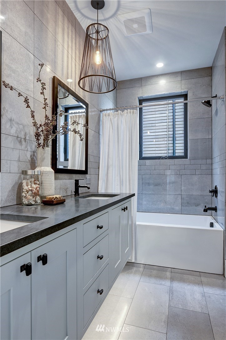 362 Ward Street Seattle, WA 98109 - Photo 21 of 40 a bathroom with a sink a large mirror and bathtub