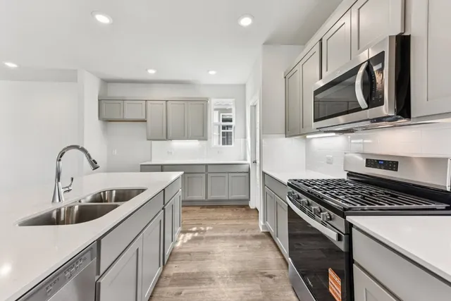 a kitchen with stainless steel appliances kitchen island granite countertop a sink and cabinets