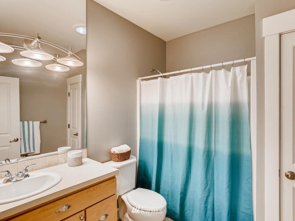 910 North 32nd Street Renton, WA 98056 - Photo 26 of 29 a bathroom with a sink a toilet a mirror and shower curtain