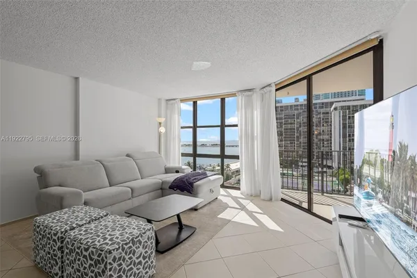 a living room with furniture and a floor to ceiling window
