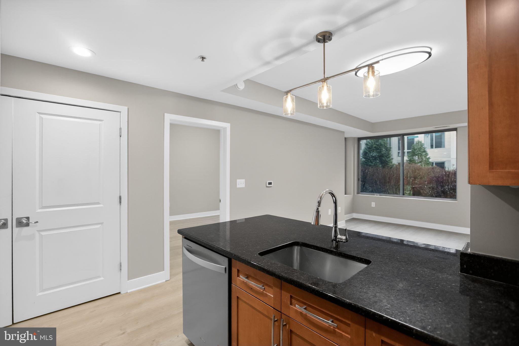 4101 Albemarle Street Northwest, Unit 317 Washington, DC 20016 - Photo 21 of 32 a kitchen with granite countertop a sink and a window