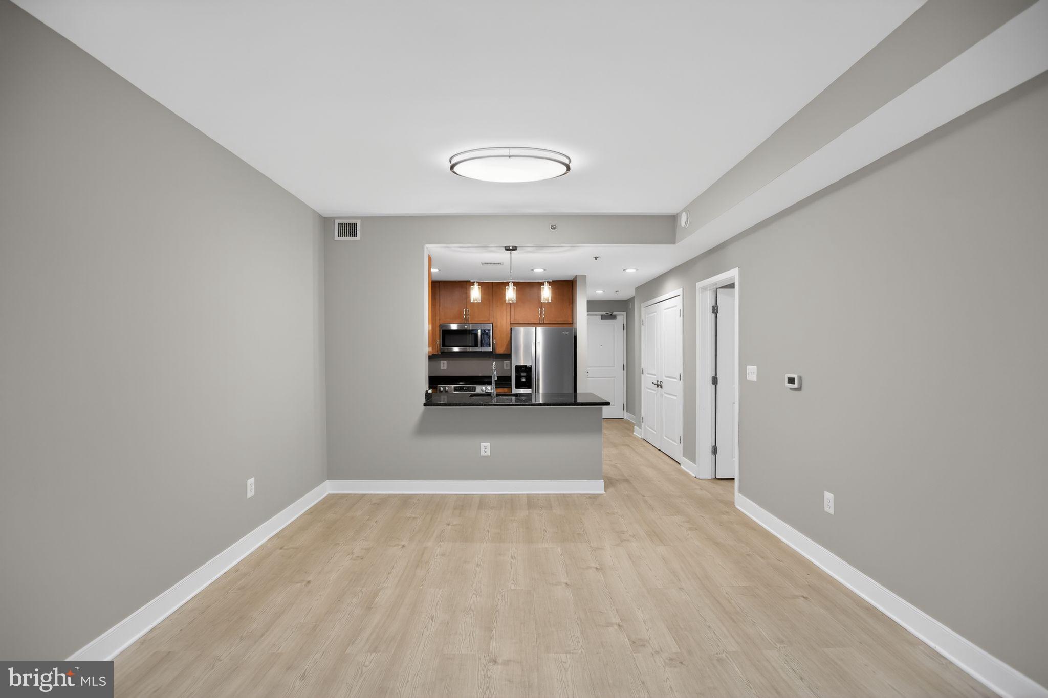4101 Albemarle Street Northwest, Unit 317 Washington, DC 20016 - Photo 8 of 32 a view of a hallway with wooden floor and a kitchen space
