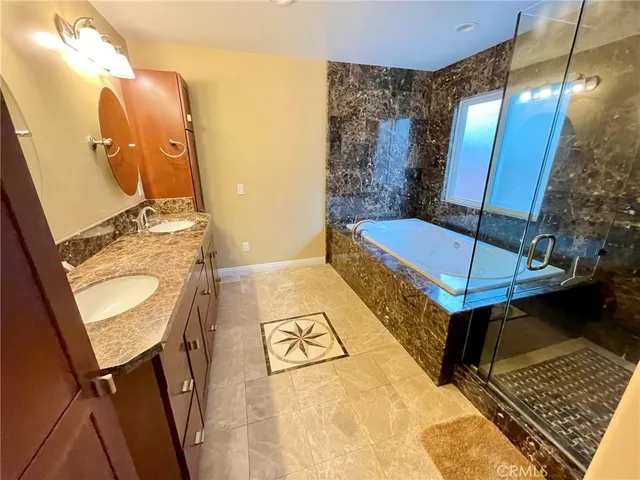 a bathroom with a tub sink and mirror