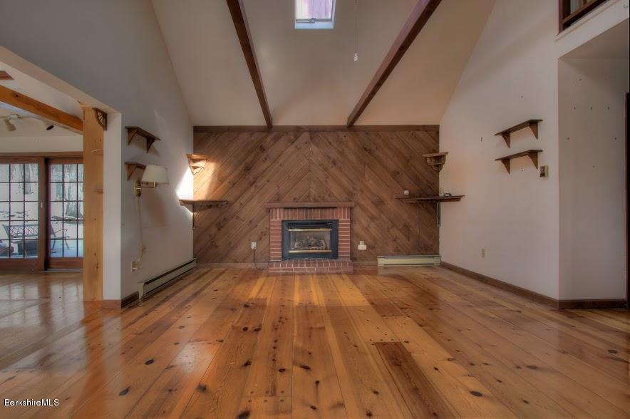 27 A Birch Road Copake, NY 12516 - Photo 7 of 16 a view of empty room with wooden floor and fireplace
