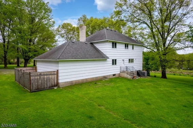 a view of a house with backyard and a tree
