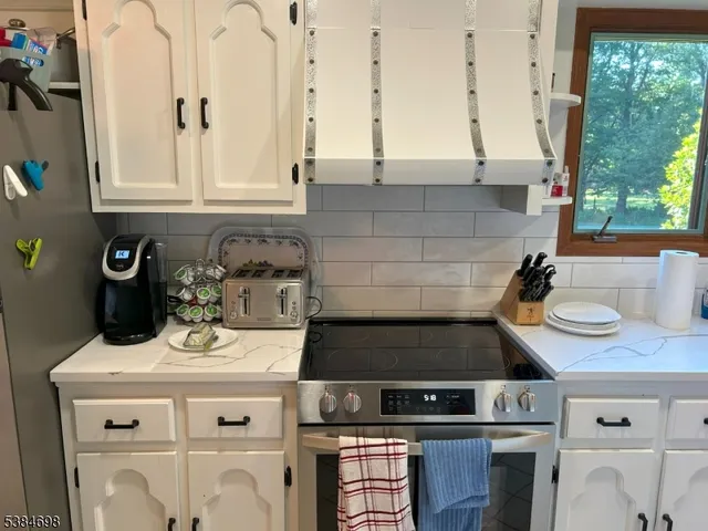 a kitchen with a stove and a white cabinets