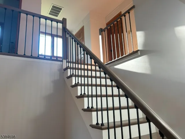 a view of staircase with lots of frames on wall and a window