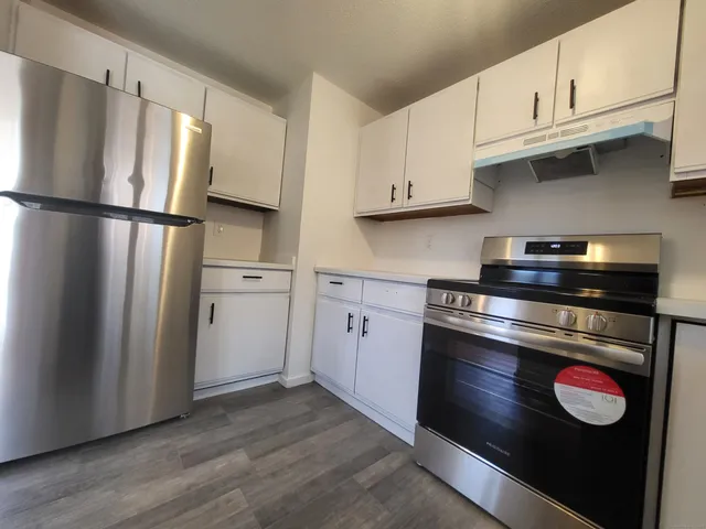 a kitchen with stainless steel appliances granite countertop a refrigerator stove and cabinets