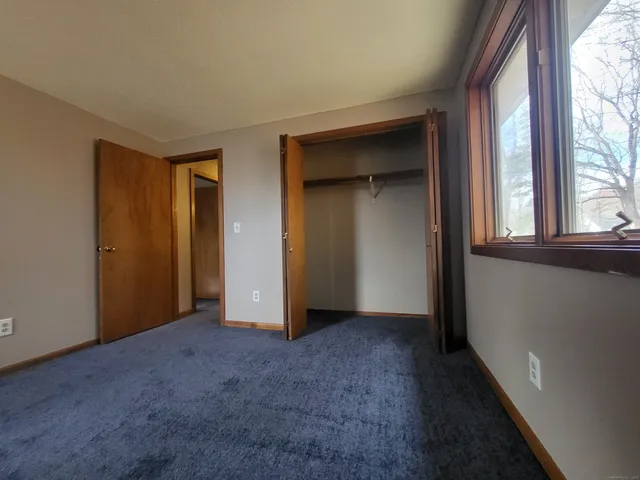 an empty room with windows and closet