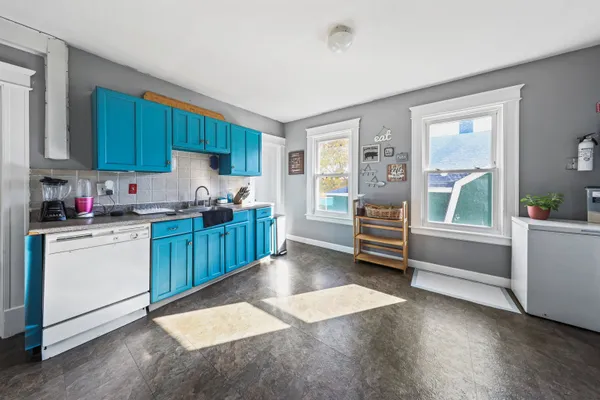 a kitchen with a refrigerator and white cabinets