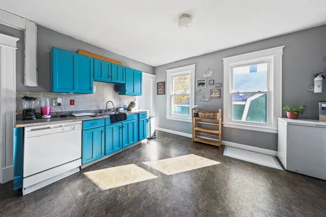 a kitchen with a refrigerator and white cabinets