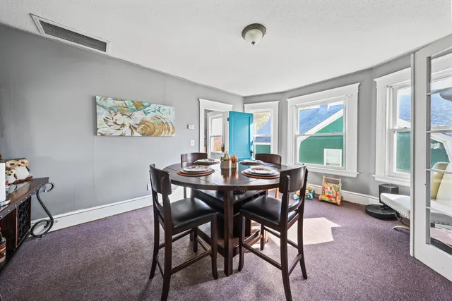 a view of a dining room with furniture and a window