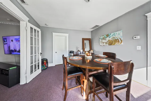 a view of a dining room with furniture and a chandelier