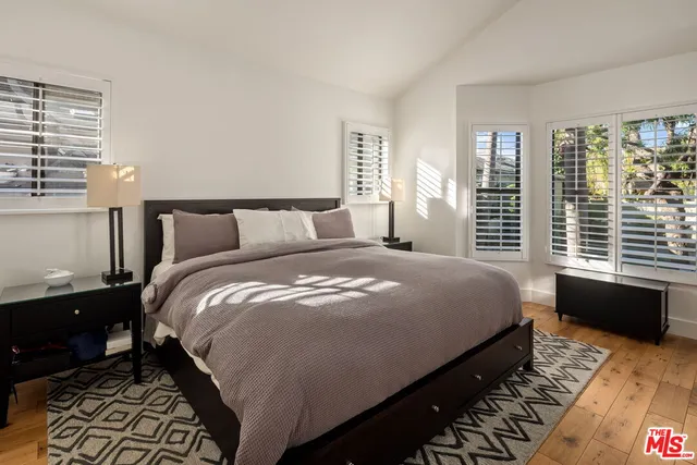 a bedroom with a bed and wooden floor