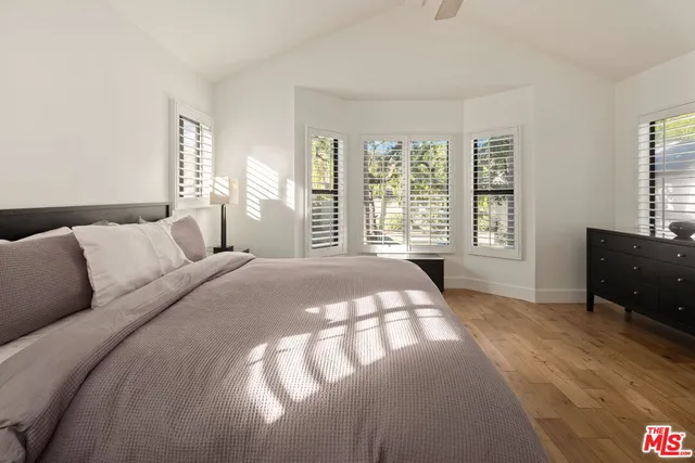 a bedroom with a bed and a large window