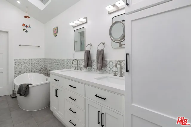 a bathroom with a double vanity sink mirror and toilet