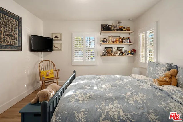 a bedroom with a bed a flat screen tv and dresser