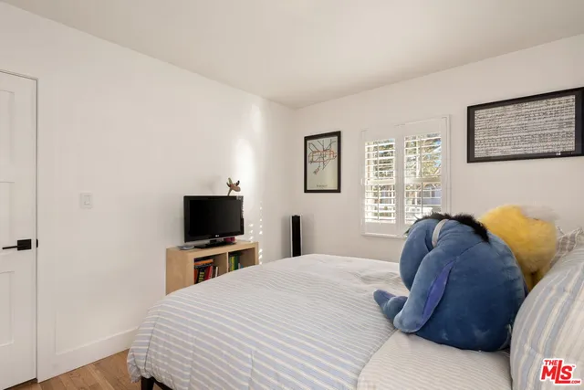 a bedroom with a bed and a flat screen tv