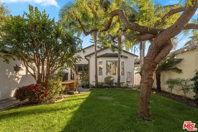 a front view of a house with a yard garden and outdoor seating