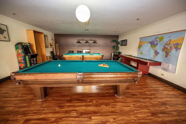 a room with pool table and lots of frames on wall