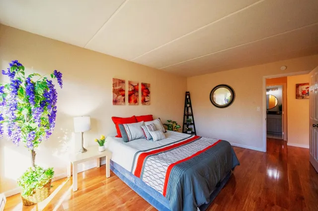 a bedroom with a bed and a potted plant