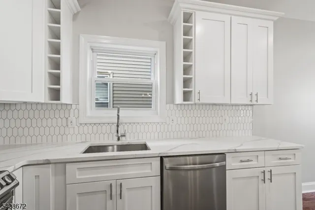 a kitchen with stainless steel appliances granite countertop a sink and a window