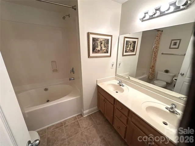 a bathroom with a tub sink and mirror