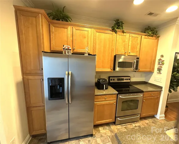 a kitchen with a refrigerator a stove top oven and sink