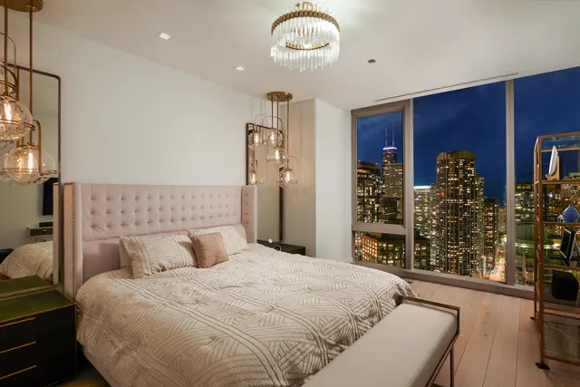 a bedroom with a large bed and a chandelier