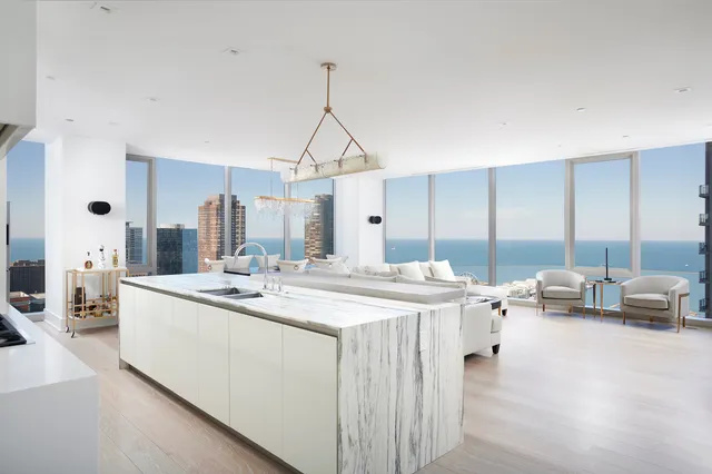a view of living room with stainless steel appliances kitchen island granite countertop furniture and a view of living room