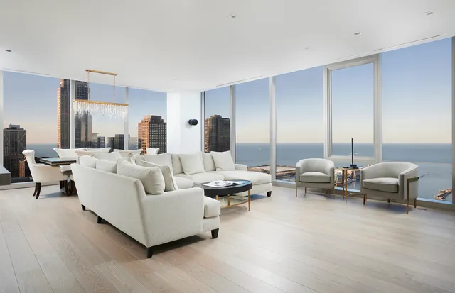 a living room with couches and kitchen view with wooden floor