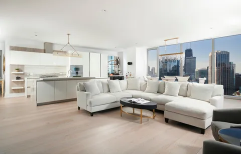 a living room with furniture white walls and kitchen view