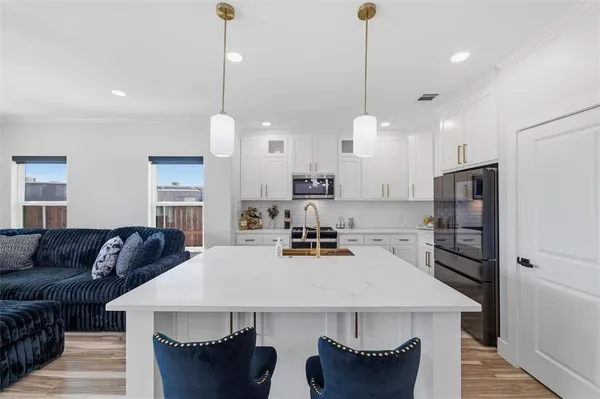 a kitchen with stainless steel appliances white cabinets sink and a stove