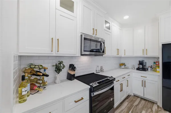 a kitchen with white cabinets and stainless steel appliances